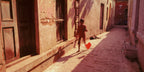 A child with a kite attempts to get it airborne.  Banaras, India.