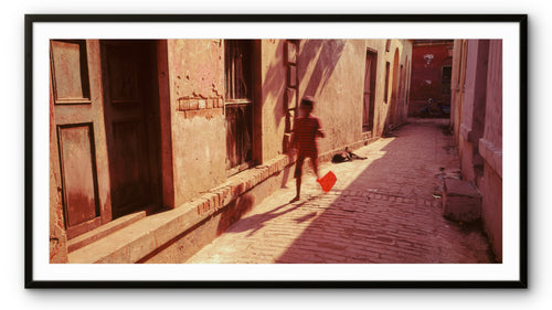 A child with a kite attempts to get it airborne.  Banaras, India.
